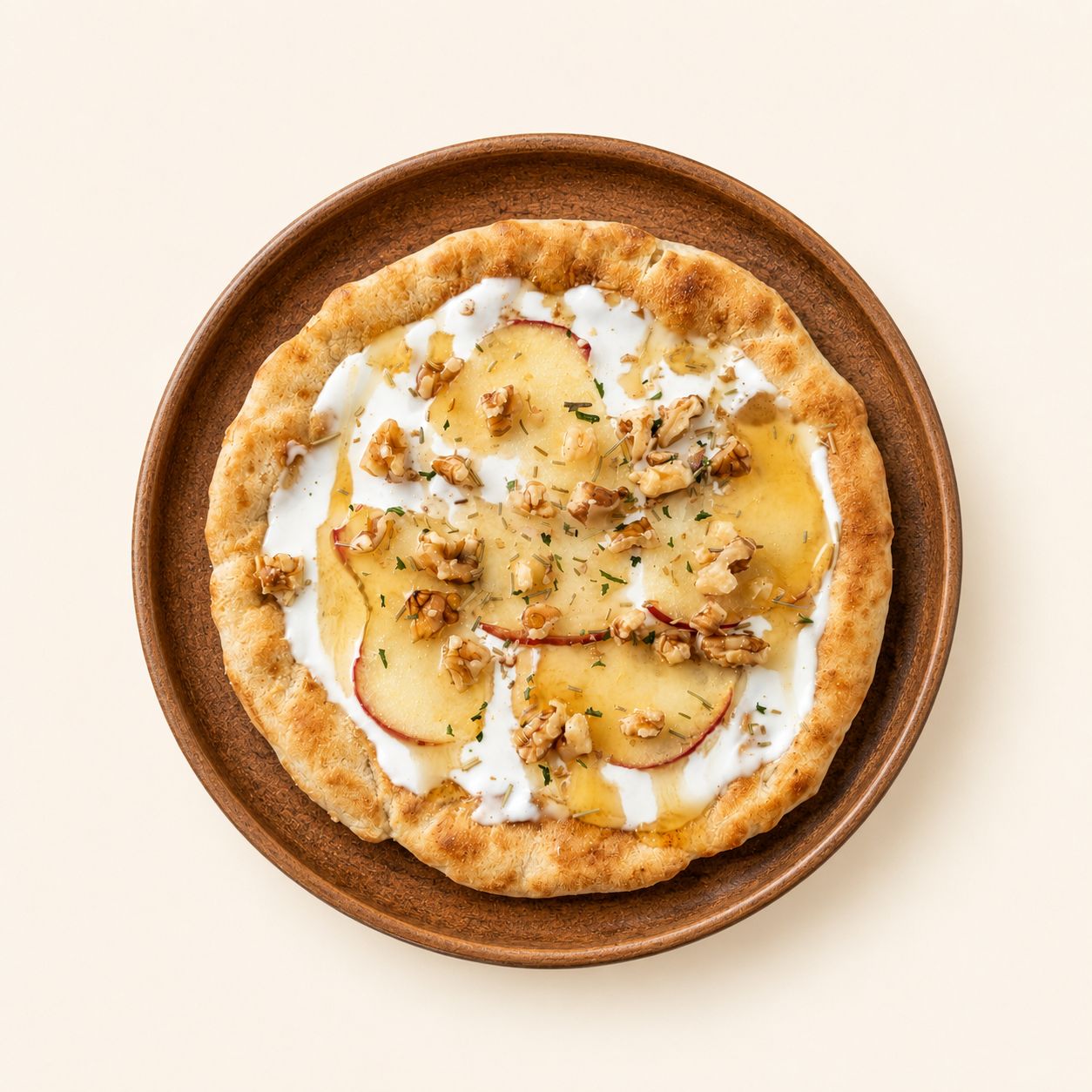 ivry.'s Honey Cream flatbread on a wooden plate — warm flatbread with cream, apple slices, walnuts and a honey drizzle.